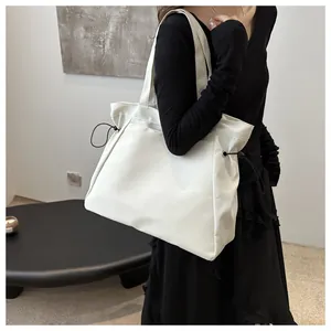 Detailed view of white large capacity tote bag with black contrast side drawstrings