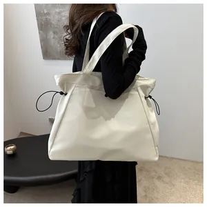 Detailed view of beige large-capacity tote bag with black drawstring details for daily use