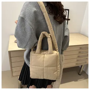 Détail du sac matelassé beige avec texture rembourrée douce et large bandoulière