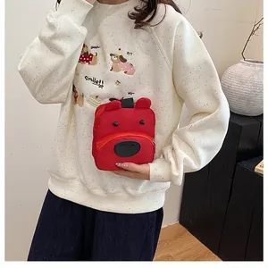 Primer plano de un pequeño bolso de lona con diseño de oso rojo y cremallera en un modelo