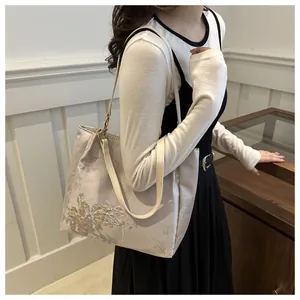 Detail of floral butterfly embroidery on a beige tote bag for women daily commute