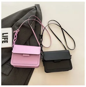 Detail of minimalist square shoulder bags in purple and black with stylish chain strap