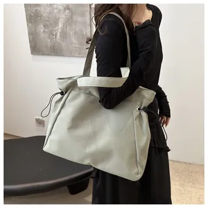Detailed side view of light sage tote bag with drawstring adjustments and nylon texture