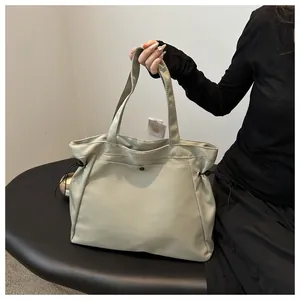 Detail of light beige tote bag with black button pocket and drawstring on a bench