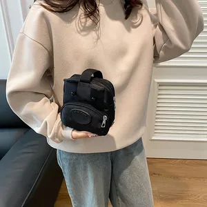 Mini bolso de lona negro con lindas orejas de oso llevado por una modelo en un interior