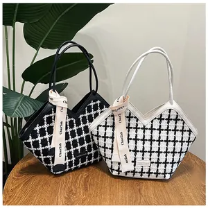 Detailansicht der gestrickten Karo-Taschen mit Ledergriffen und eleganter Bandschleife