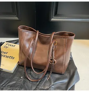 Close-up of vintage brown leather tote bag showing smooth texture and side cord detail