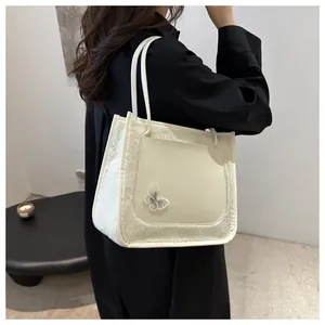 Détail du sac cabas en laine d'agneau pelucheuse avec broderie papillon argentée sur le devant