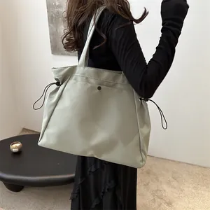 Large sage green nylon tote bag with drawstring details and sleek satin finish for women