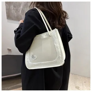 Détail de la bordure en peluche, du panneau ivoire et de la broderie papillon sur le sac