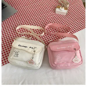 Vue détaillée de l'imprimé teckel et du porte-clé peluche sur petits sacs bandoulière