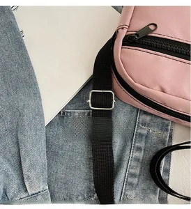 Detailed close-up of a pink nylon crossbody bag with an adjustable silver metal buckle