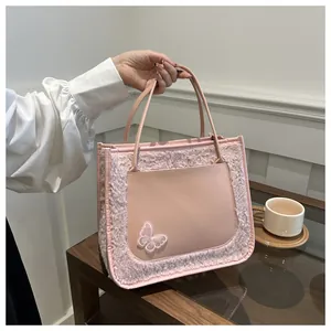 Détail du sac fourre-tout rose en peluche avec poche en similicuir et nœud papillon