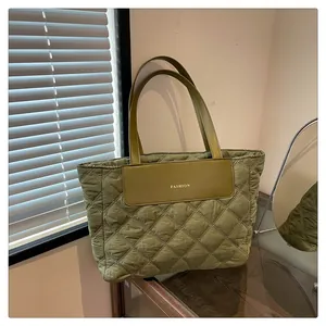 Close-up of olive green quilted nylon tote bag with fashion tag and long shoulder straps