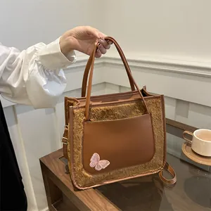 Sac fourre-tout marron en peluche avec poche en cuir et broderie de papillon rose