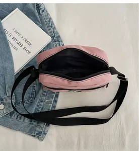 Pink canvas crossbody bag featuring organized interior compartments and durable zippers