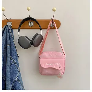 Détail du sac à bandoulière rose avec imprimé teckel et pendentif en acrylique doux