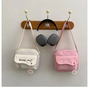 Détail de sacs bandoulière minimalistes avec motif chiot et pendentifs mignons