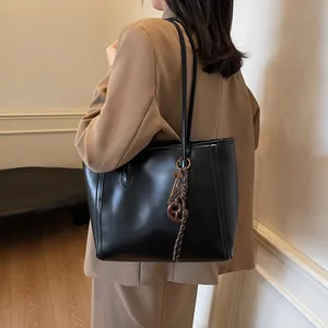 Classic black leather tote bag with braided handle detail for elegant office commute