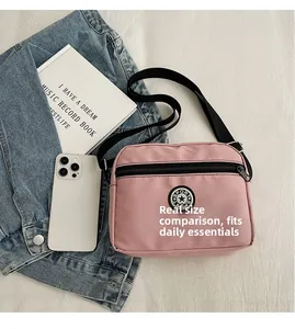 Practical capacity of pink nylon crossbody bag with strap, phone and book for size comparison