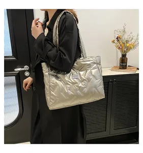 Detail of silver quilted tote bag with metallic finish and rectangular fashion label