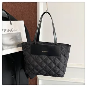 Detail of black quilted tote bag with diamond stitching and Fashion leather patch