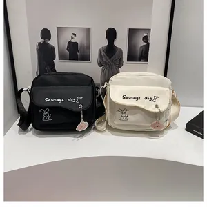 Détail de sacs bandoulière en nylon avec imprimé chien et charms mignons assortis