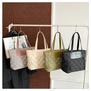 Detailed view of four quilted nylon tote bags in grey, beige, green, and black colors