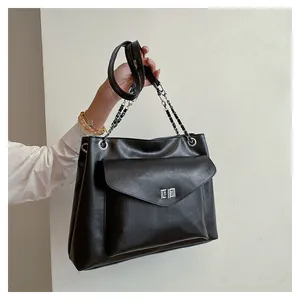 Detailed close-up of a black tote bag with silver twist lock and chain strap details