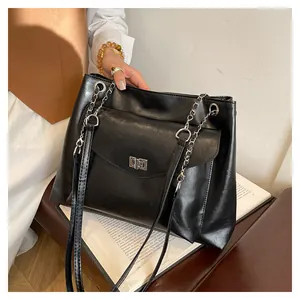 Close-up of black PU leather tote bag featuring a silver turn-lock and chain strap