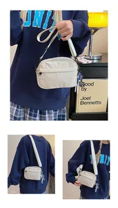 Détail d'un sac bandoulière en nylon beige avec poche zippée et sangle réglable