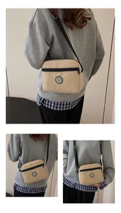 Detail of khaki nylon crossbody bag featuring black zipper and SPORT logo badge