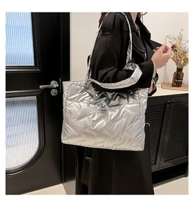 Detail of silver metallic quilted tote bag with diamond pattern and Fashion label