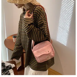 Détail de la bandoulière réglable sur le sac rose en toile avec imprimé chien mignon