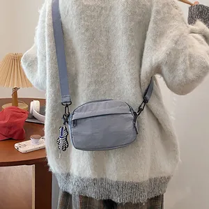 Sac bandoulière en nylon imperméable bleu pastel avec charm ours en damier chic