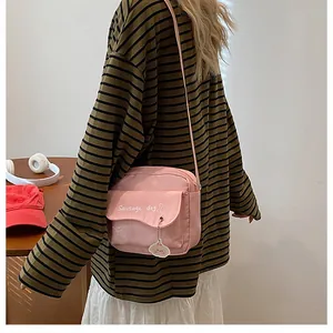Détail du sac bandoulière rose avec imprimé teckel et pendentif chiot mignon