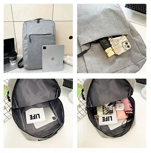 Detail view of the gray backpack showing internal storage compartments and front pocket