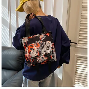 Close-up of a nylon crossbody bag with street graffiti print and buckle closure detail