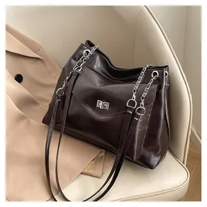 Close-up of dark brown leather tote bag with silver metal lock and chain strap