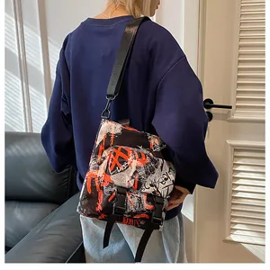 Detail of street-style graffiti nylon messenger bag with buckle closure on model