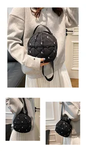 Detailed views of a black quilted mini backpack featuring white bow embroidery and top handle
