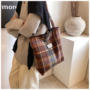 Dettaglio di una borsa tote in lana a quadri con trama ricca ed etichetta in tessuto