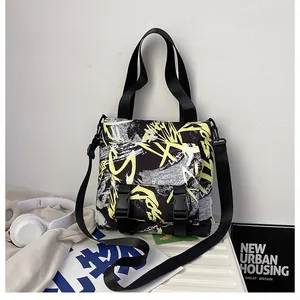 Detail of street graffiti nylon messenger bag with buckle closure and urban graphics