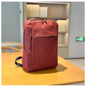 Deep red business backpack with water-resistant fabric on a wooden desk with bokeh library view