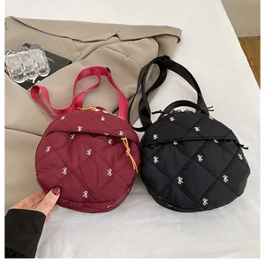 Detailed top view of quilted round crossbody bags with bow embroidery in black and wine red
