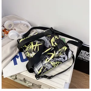 Detailed view of nylon messenger bag with yellow graffiti art on white suitcase