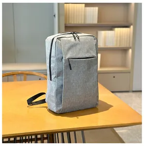 Close-up of light grey business laptop backpack with side water bottle pocket on wood desk