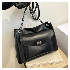 Detail of black PU leather tote bag with silver chain strap and front swivel lock pocket