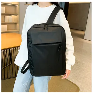 Close-up of black water-resistant backpack with wide straps worn in a modern office setting