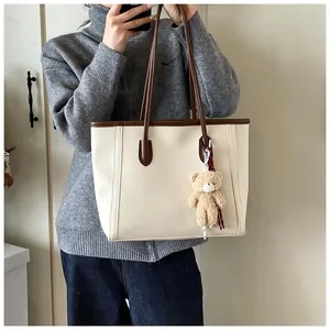 Dettaglio della borsa tote in pelle martellata bianco sporco con manici marroni